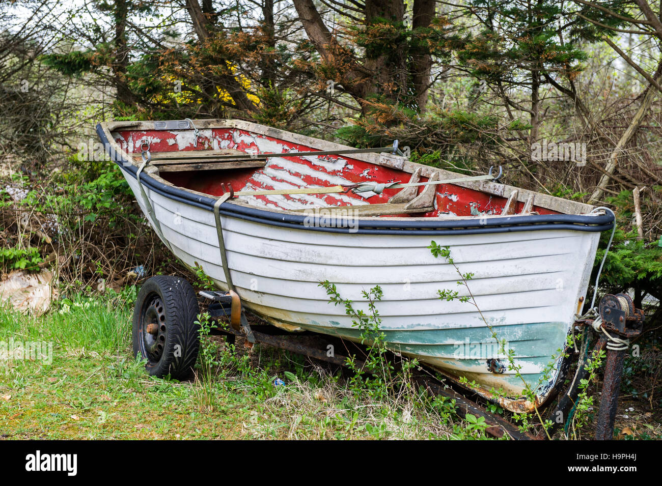Eine verlassene/Verrottung Boot auf einem Anhänger in einem Garten. Stockfoto