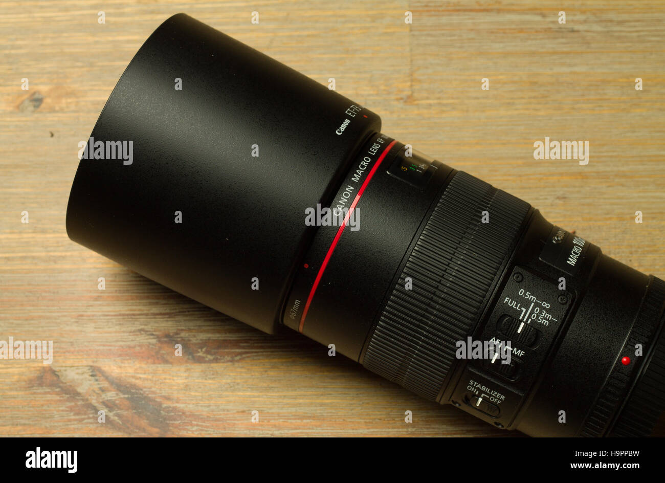 TALLINN, Estland HARJUMAA - 6. November 2016: Canon schwarz gefärbt-Objektiv mit einer Haube auf einem braunen Tisch Stockfoto