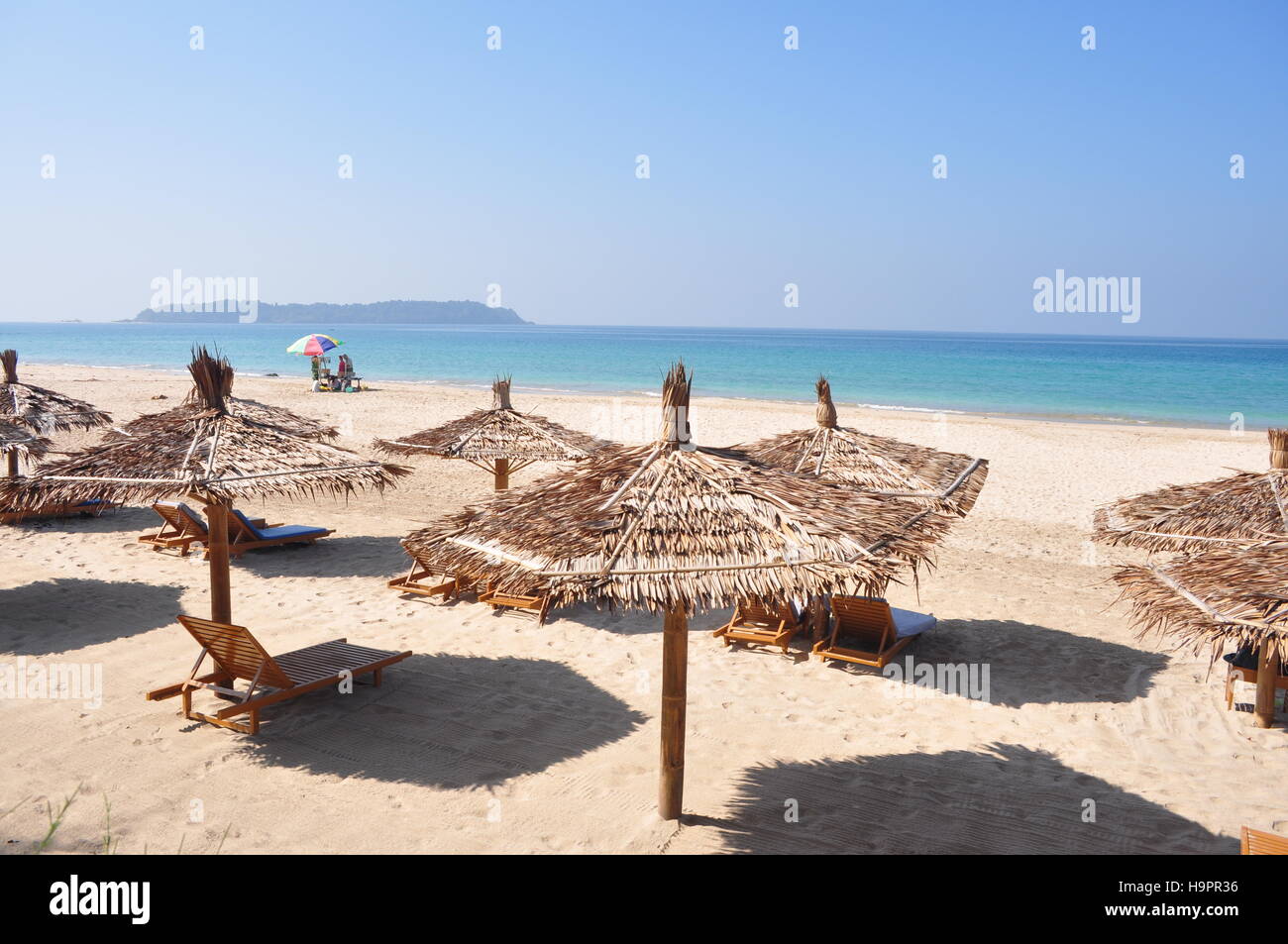 Holz Sonnenschirme und Strandliegen am schönen Ngapali Strand, Myanmar, Burma Stockfoto