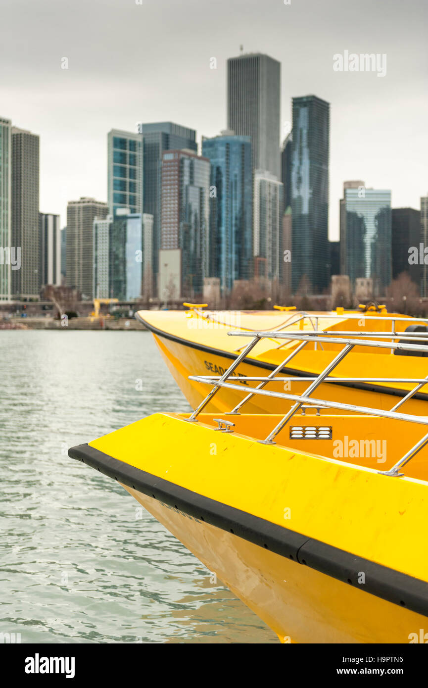 Gelbe Tour Schnellboote angedockt am Navy Pier, Lake Michigan, mit der Innenstadt Chicagos Gebäude im Hintergrund Stockfoto