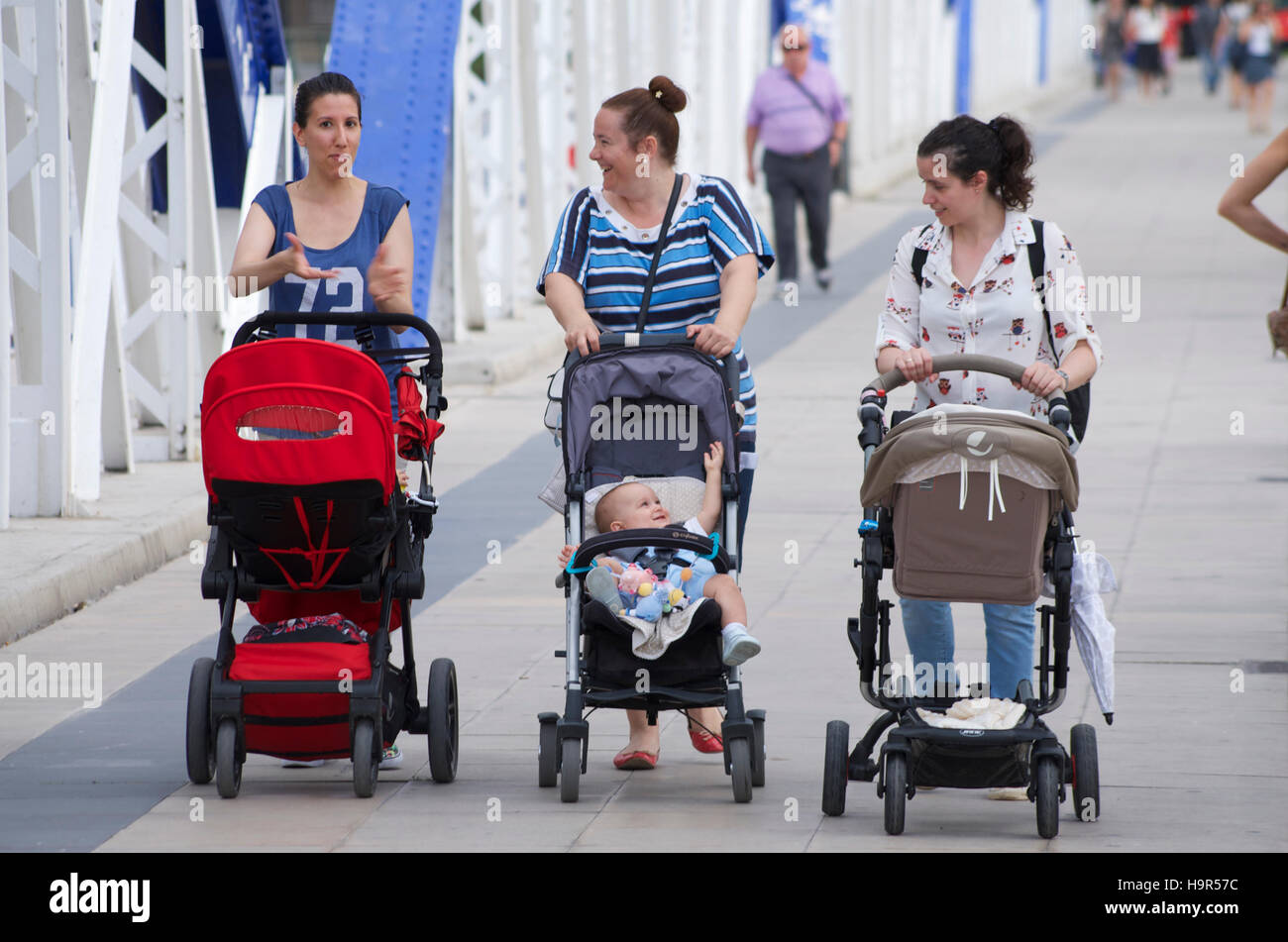 Gruppe von Müttern, die Kinderwagen schieben, über die Puente de Hierro in Zaragoza, Spanien Stockfoto