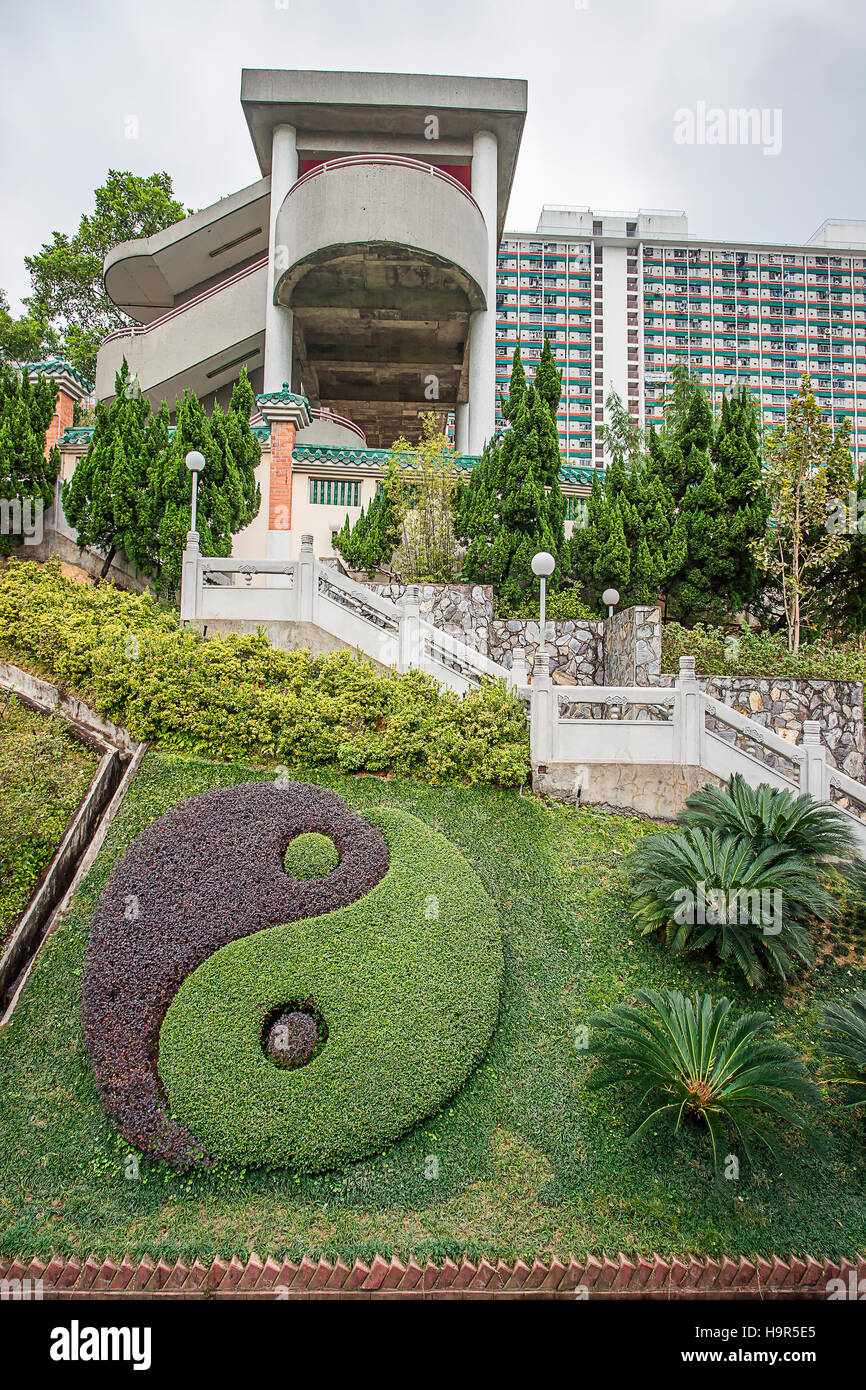 Hong Kong, Hong Kong - 13. Januar 2012: Yin und Yang-Symbol im Garten Gottes Wunsch zwischen Wolkenkratzern der Stadt im Wong Tai Sin Tempel in Kowloon in Ho Stockfoto