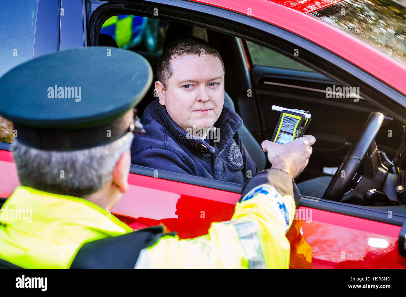 Belfast, Nordirland. 24. November 2016 - bläst ein Treiber in ein am Straßenrand handheld Alkohol Atem Tester Alkoholtester, während er von einem Polizisten Verkehr stattfindet. Bildnachweis: Stephen Barnes/Alamy Live-Nachrichten Stockfoto