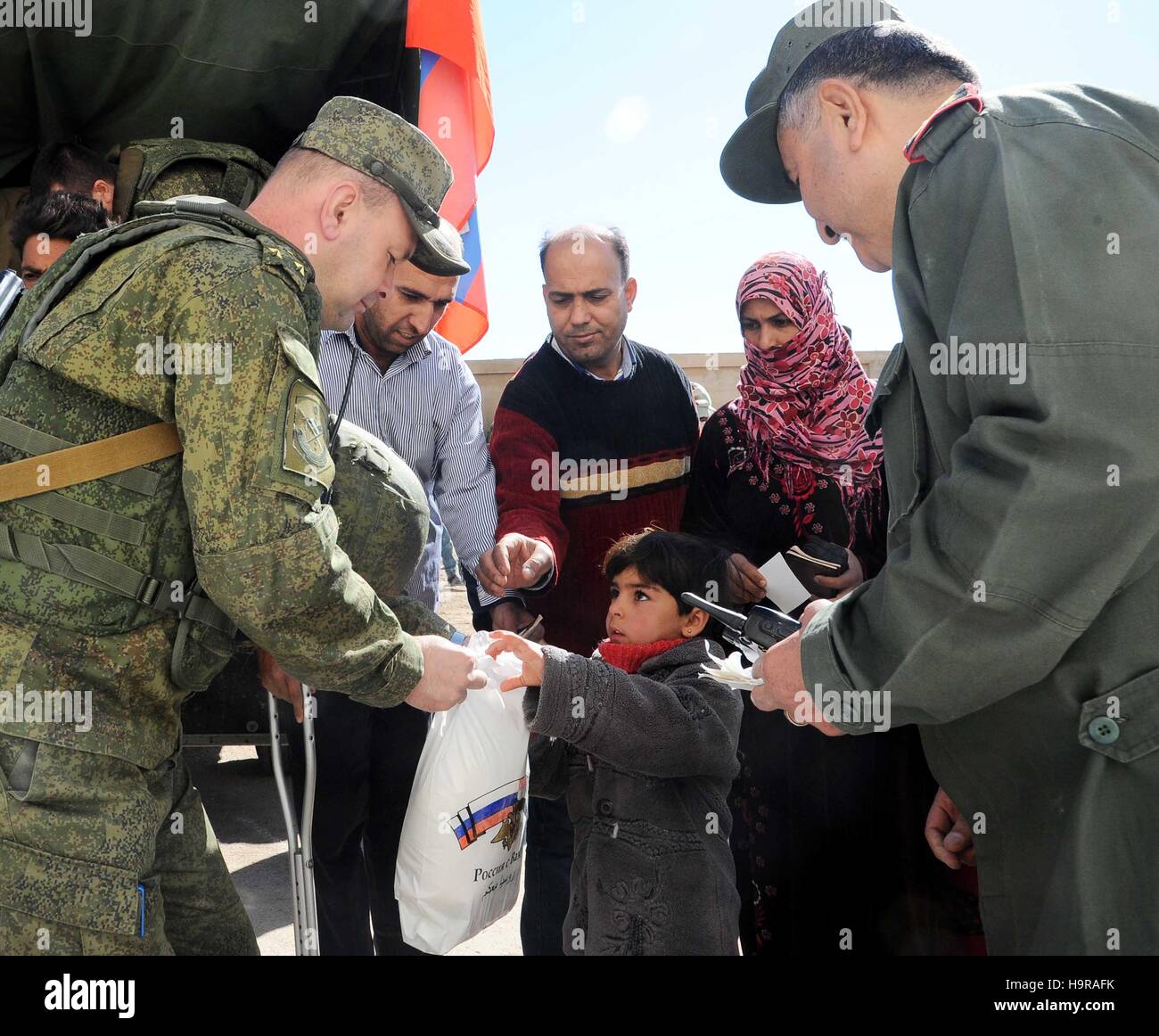 Damaskus, Syrien. 24. November 2016. Ein russischer Soldat übergibt eine Packung von Hilfe ein Kind in Damaskus, Syrien, 24. November 2016. Russland hat immer wieder Hilfsgüter kriegsmüde Syrer im Krieg-heftig gezerrissenes Land geschickt. © Ammar Safarjalani/Xinhua/Alamy Live-Nachrichten Stockfoto