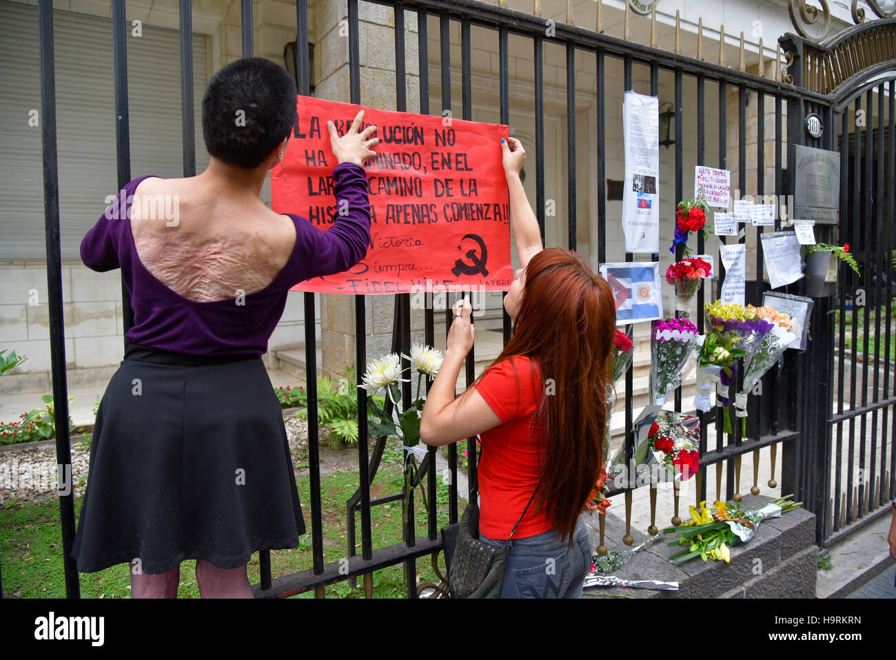 Buenos Aires, Argentinien - 26. November 2016: Frauen ein Plakat an einem Zaun aufstellen, Fidel Castro an der Botschaft von Kuba in Buenos Aires, Argentinien zu würdigen. Stockfoto