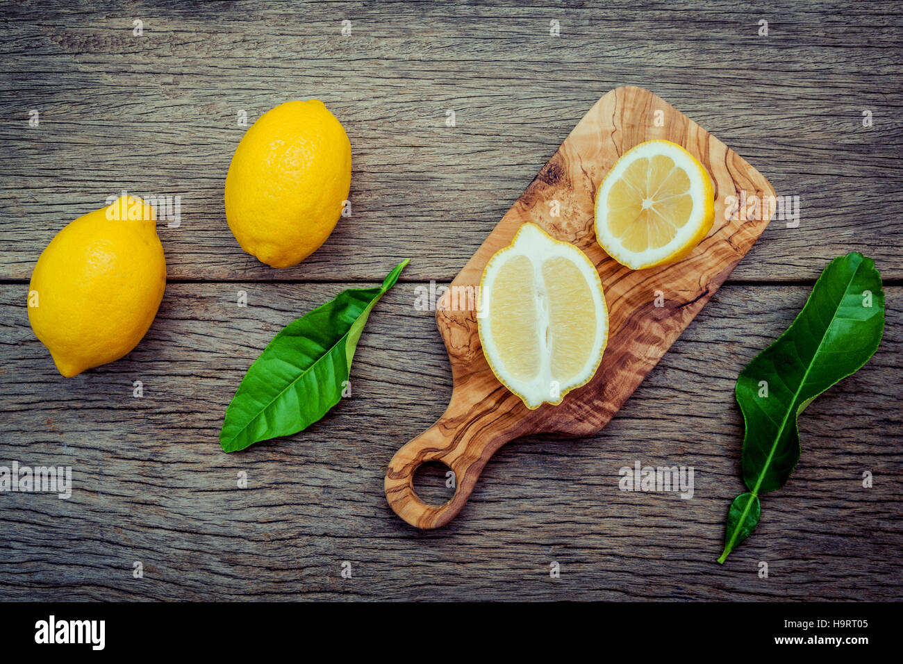Frische Zitronen und Zitronen Blätter auf rustikalen hölzernen Hintergrund. Fre Stockfoto
