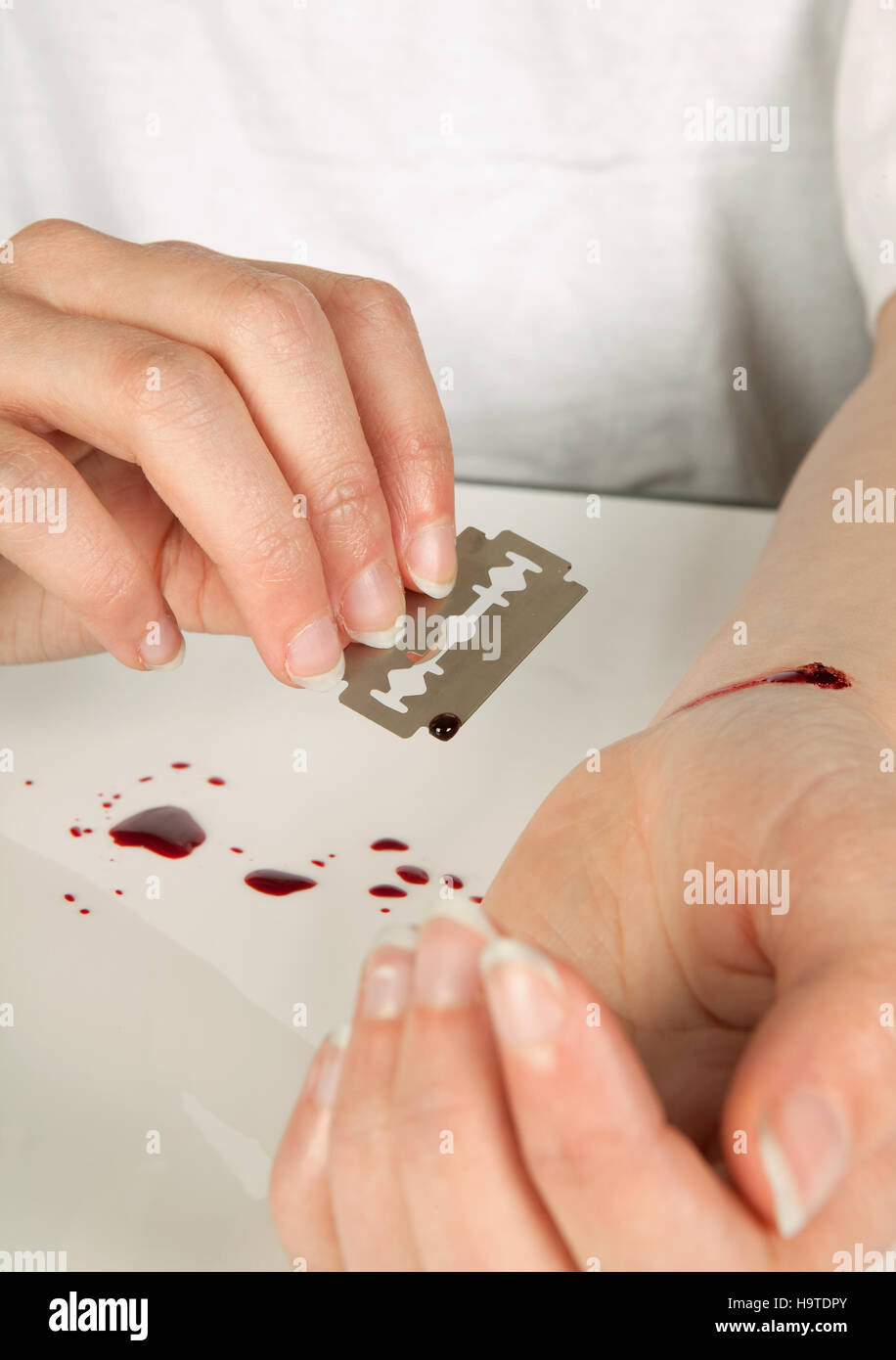 Selbstmordversuch einer Hand mit einer Rasierklinge Stockfoto