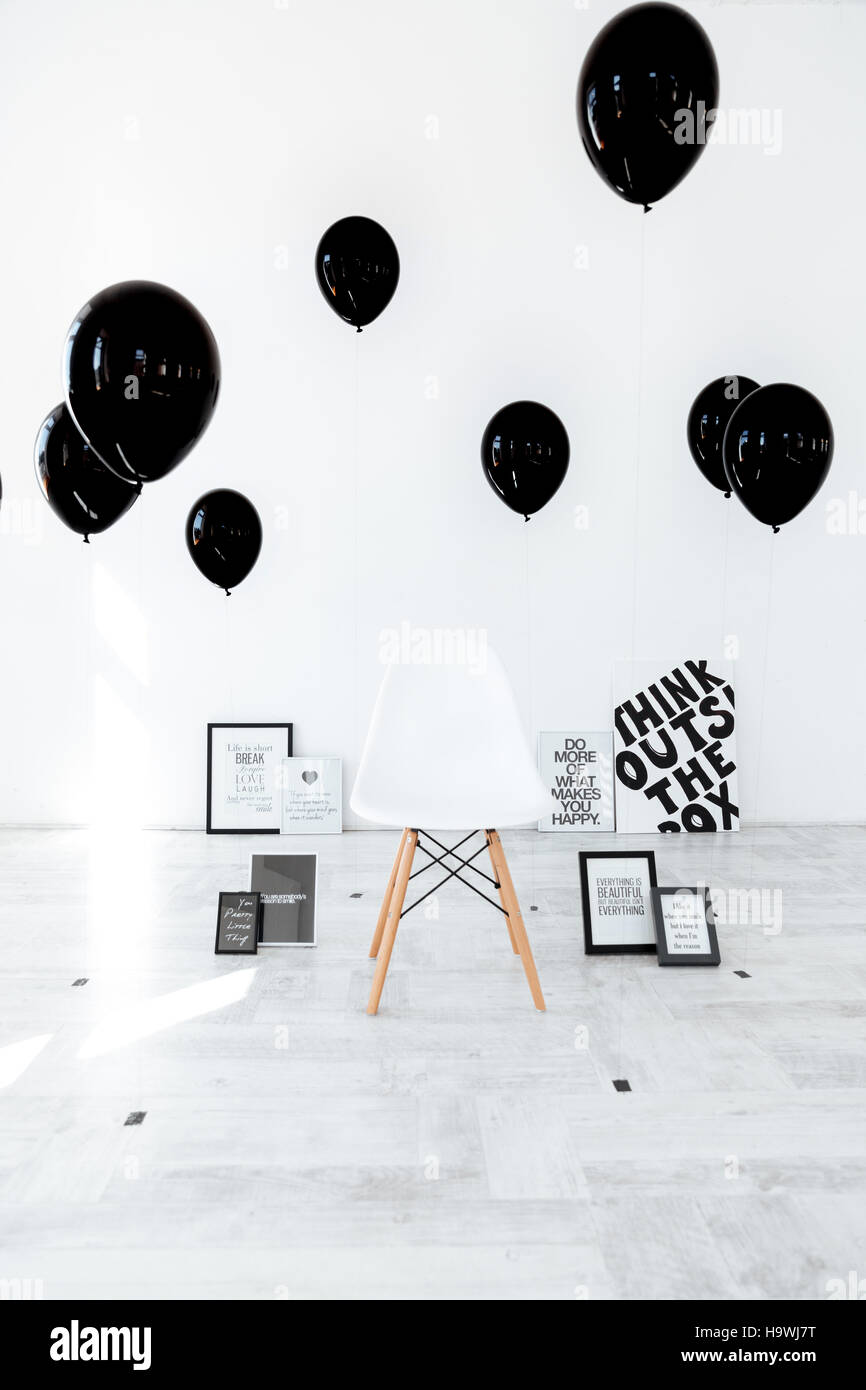 Stuhl, schwarze Plakate und Luftballons isoliert auf weißem Hintergrund Stockfoto