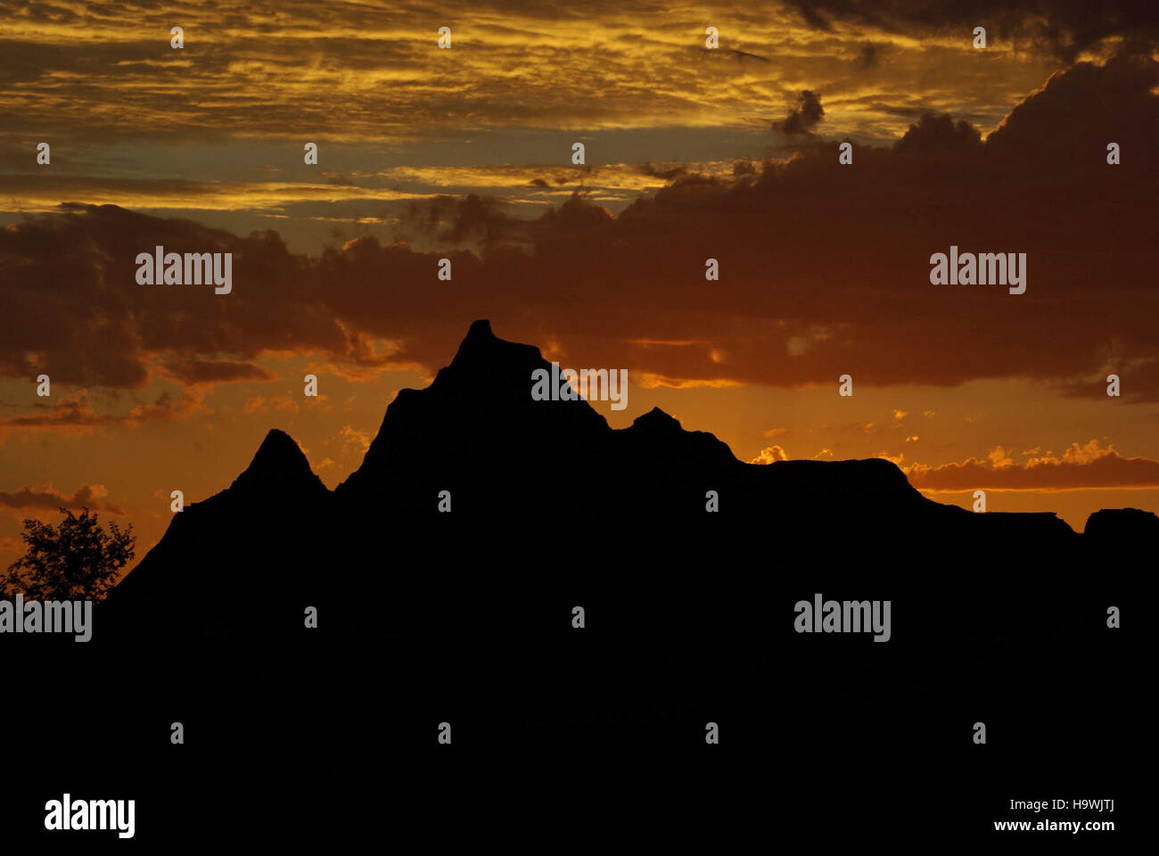 Der Sonnenuntergang im Badlands National Park unterstreicht die dramatische Landschaft des Parks mit seinen einzigartigen geologischen Formationen und lebhaften Farben, wobei der Schwerpunkt auf natürlicher Schönheit und Naturschutz gelegt wird. Stockfoto