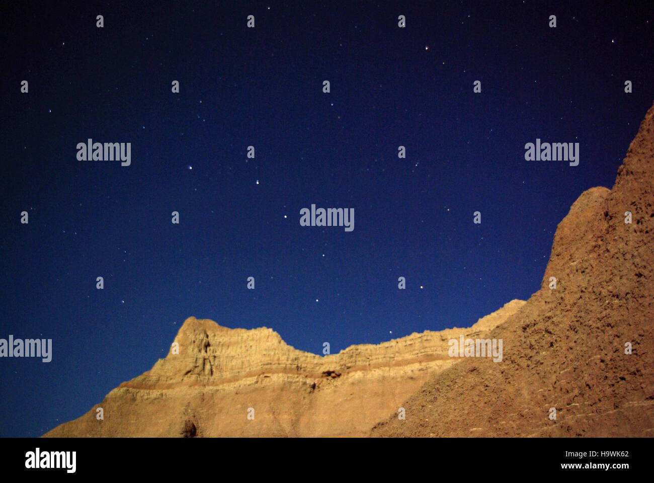 Dieses Bild zeigt den Big Dipper und einzigartige Felsformationen im Badlands National Park, einem Ort, der für seine beeindruckende Geologie und den dunklen Himmel bekannt ist und einen Einblick in die natürliche Schönheit des Parks bietet. Stockfoto