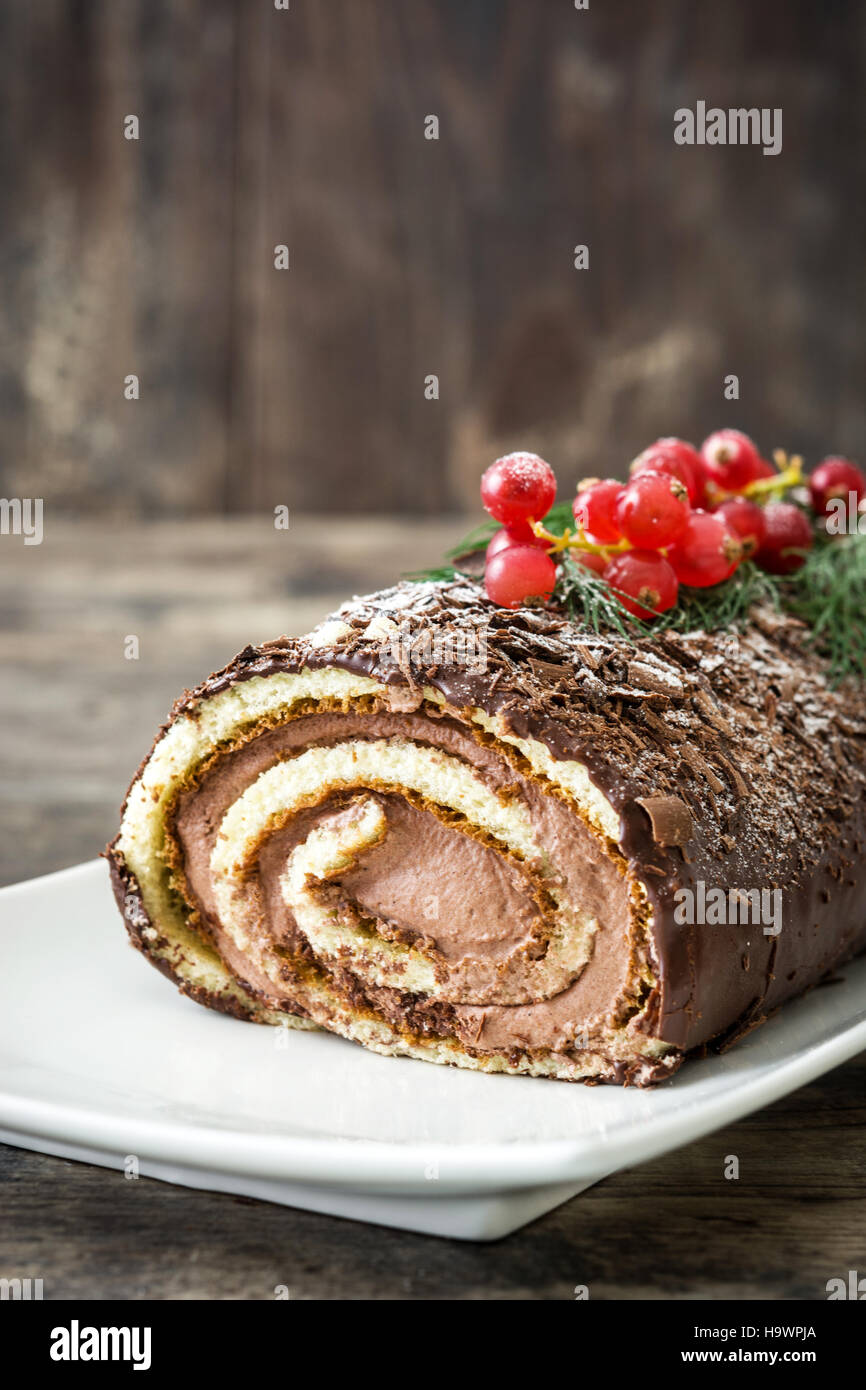 Schoko Yule Log Weihnachtskuchen mit roten Johannisbeeren auf hölzernen ...