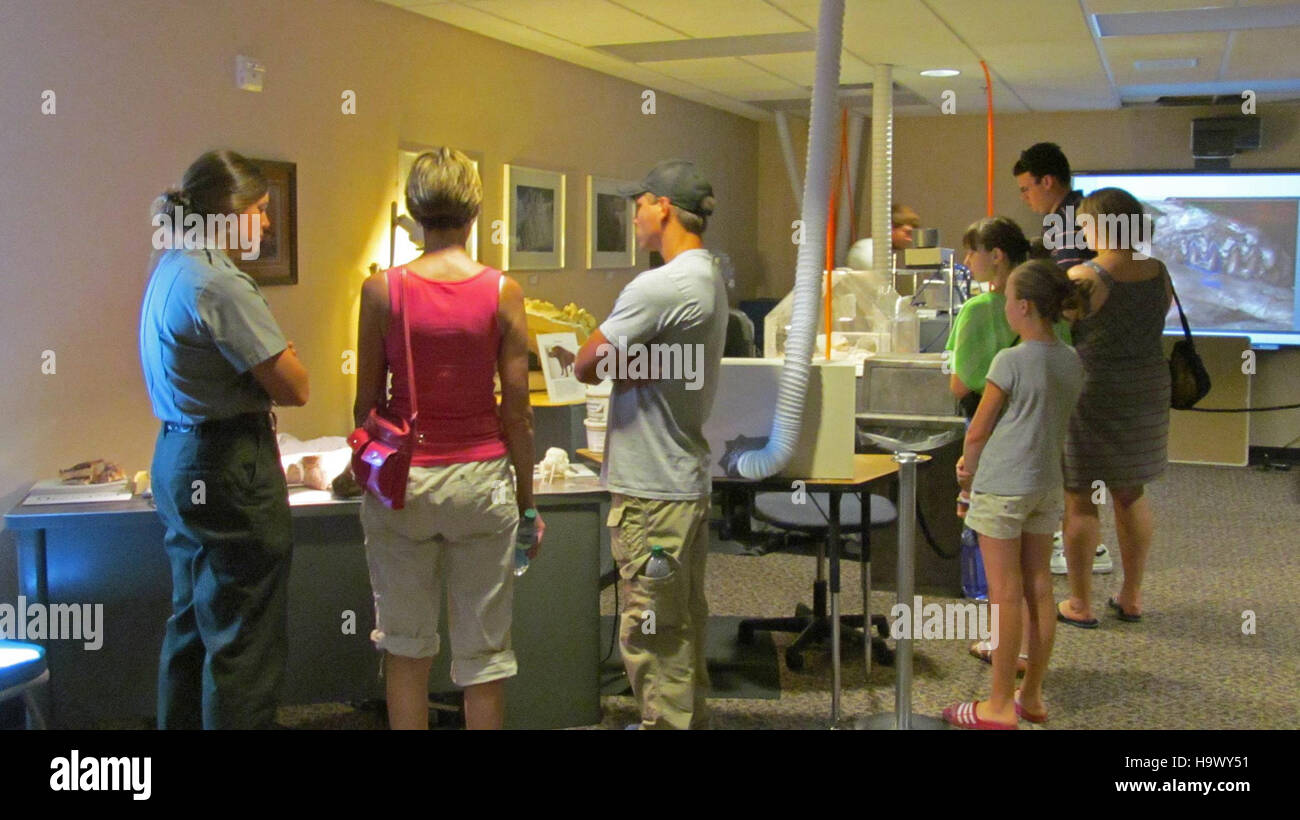 Dieses Bild zeigt Ranger Dakota McCoy, der den Besuchern des Fossil Prep Lab im Badlands National Park den Prozess der Fossil-Zubereitung erklärt und die pädagogische und wissenschaftliche Rolle des Parks für die Erhaltung der paläontologischen Geschichte unterstreicht. Stockfoto
