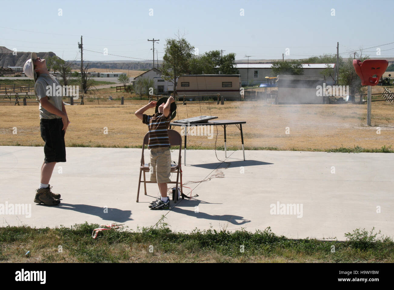 Ein Foto, das im Badlands-Nationalpark aufgenommen wurde und einen Raketenstart in der Ferne zeigt. Das Bild fängt die dramatische Landschaft des Parks ein und konzentriert sich dabei auf den Aufstieg der Rakete und bietet eine einzigartige Gegenüberstellung von Natur und menschlicher Technologie. Stockfoto