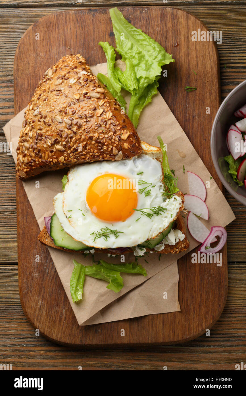 Frühstücks-Sandwich mit Ei und Salat auf Holz Stockfoto