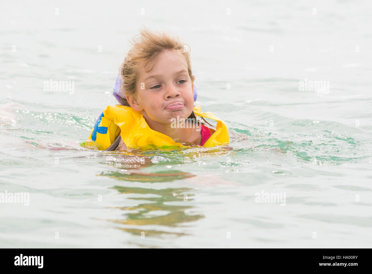 Fünfjähriges Mädchen streckte ihre Zunge gerne schwimmen im Meer Stockfoto