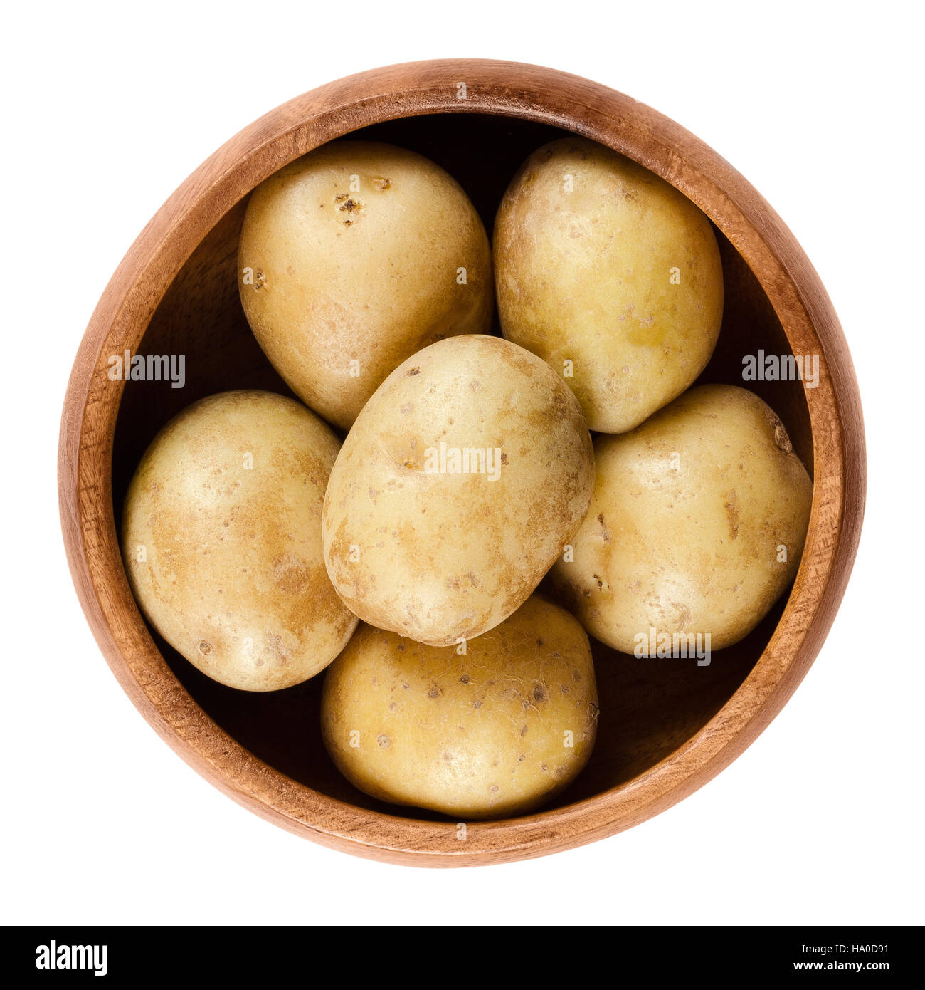 Rohe Mini Kartoffeln in Holzschale. Essbare Knolle von Nachtschatten Solanum Tuberosum, eine stärkehaltige Ernte. Isolierte Makrofoto Essen. Stockfoto