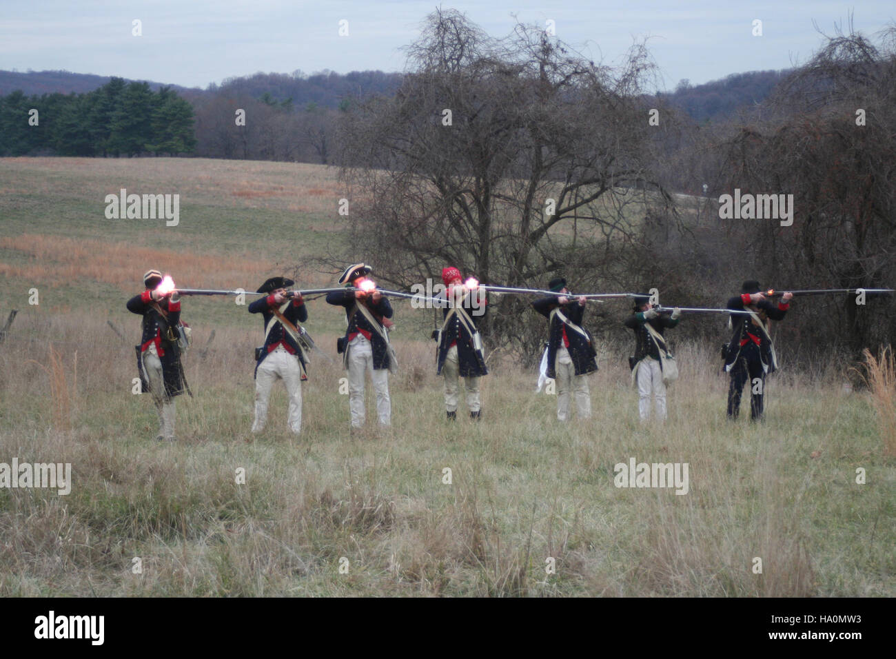 Das Bild zeigt Soldaten, die im Valley Forge National Historical Park Musketen feuern und Ereignisse aus der Amerikanischen Revolution nachspielen. Er unterstreicht die Rolle des Parks bei der Bewahrung historischer Ereignisse und der Aufklärung der Öffentlichkeit über die historische Bedeutung des Unabhängigkeitskriegs und seine Auswirkungen auf die amerikanische Geschichte. Stockfoto