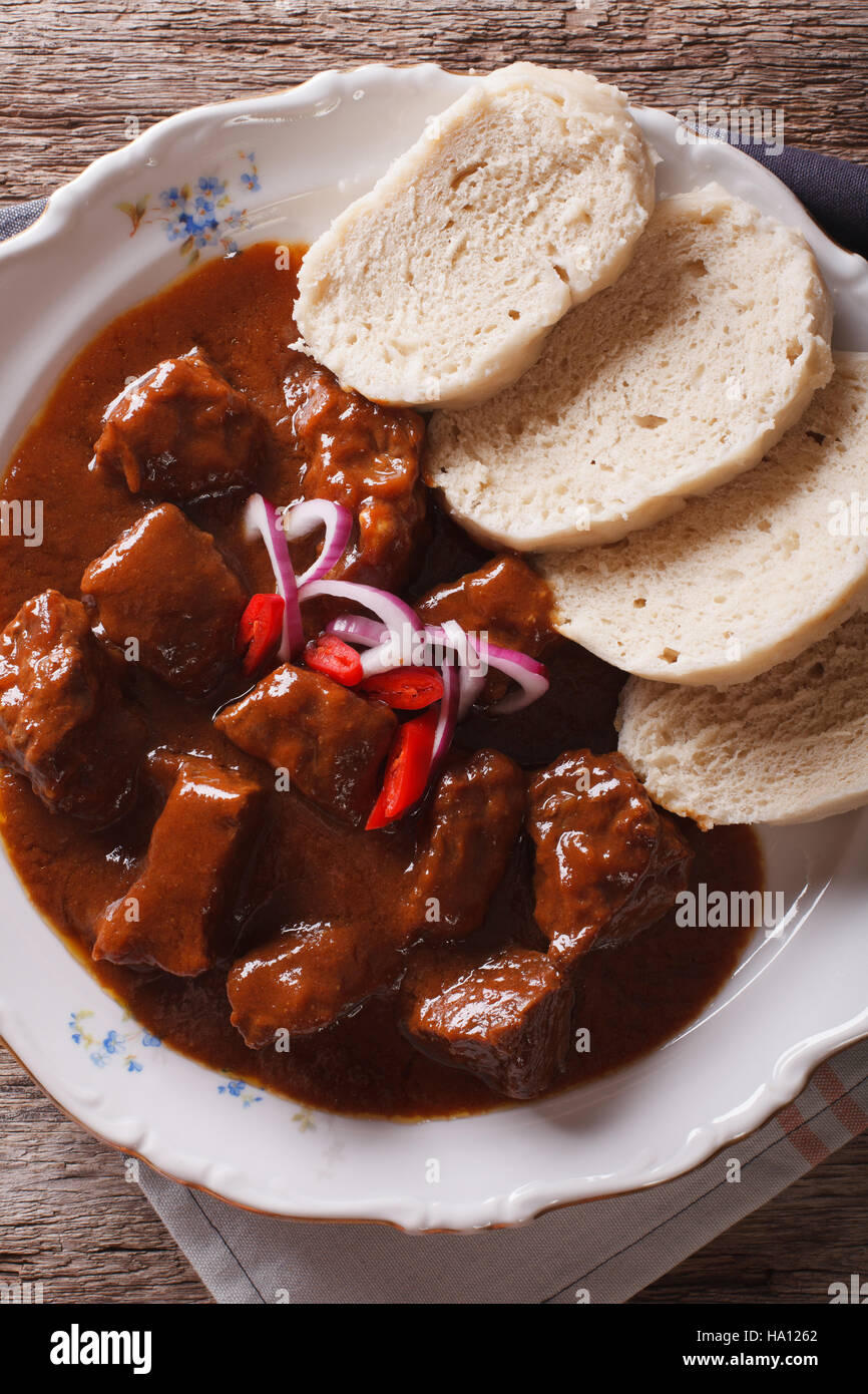 Böhmische Küche Rindfleisch Gulasch mit Knödel Makro auf einem Teller. vertikale Ansicht von