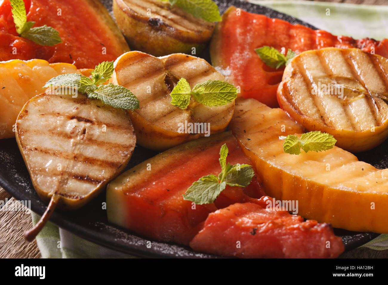 Obst zubereitet auf dem Grill Wassermelone, Melone, Apfel, Birne mit Minze auf einem Teller-Makro. horizontale Stockfoto