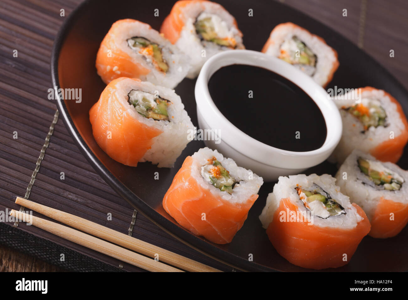 Philadelphia Maki Sushi hergestellt aus frischen rohen Lachs, Frischkäse und Gurken auf einem Teller. Horizontale Stockfoto