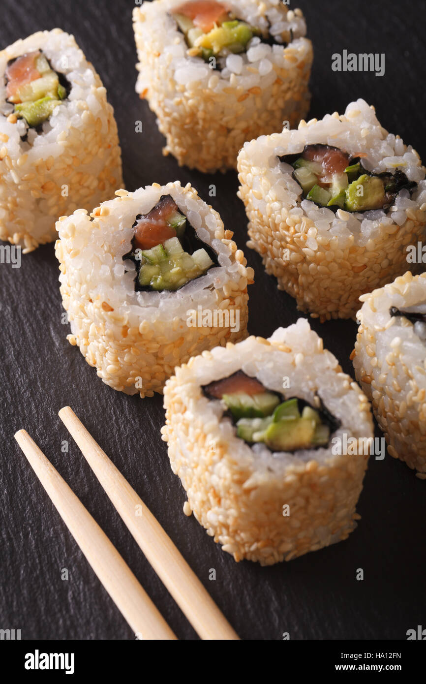 Japanische California roll mit Lachs in Sesam-Makro. Vertikal Stockfoto