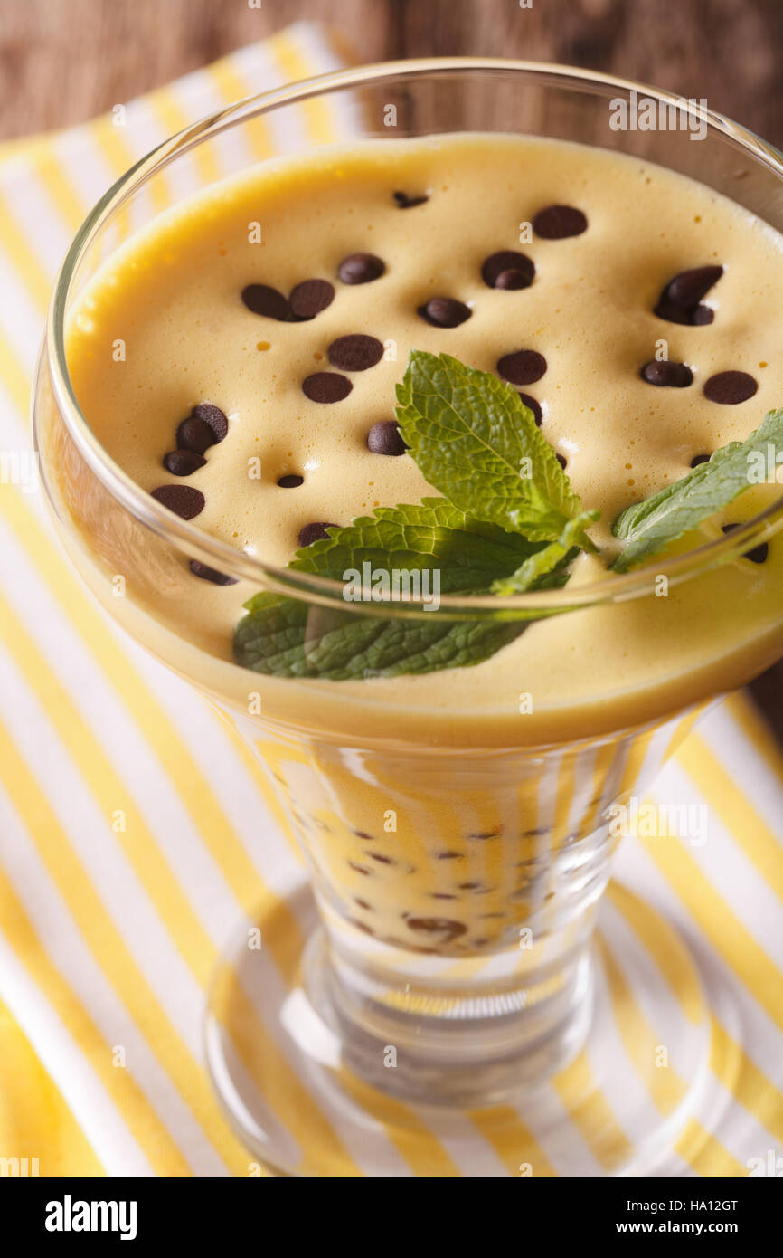 Ei-Sahne-Sabayon mit Schokolade Tropfen in einem Glas hautnah. vertikale Stockfoto