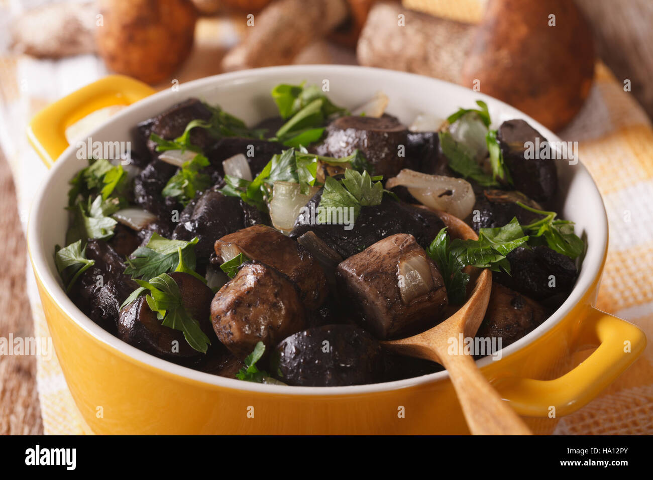 Steinpilze gebraten mit Zwiebeln und Petersilie in einer Pfanne Nahaufnahme. horizontale Stockfoto