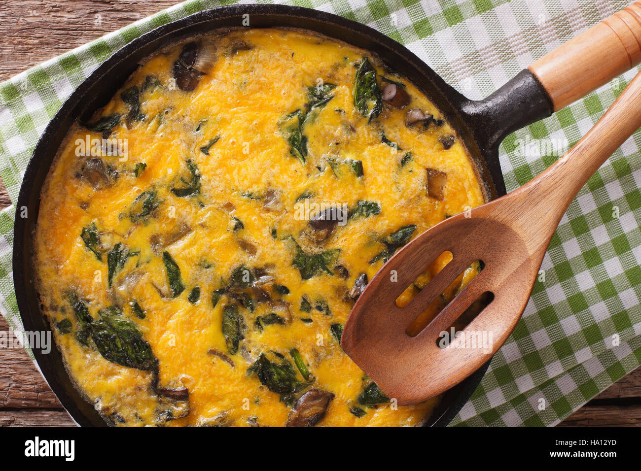 Leckeres Omelette mit Spinat, Cheddar-Käse und Pilzen in einer Pfanne ...