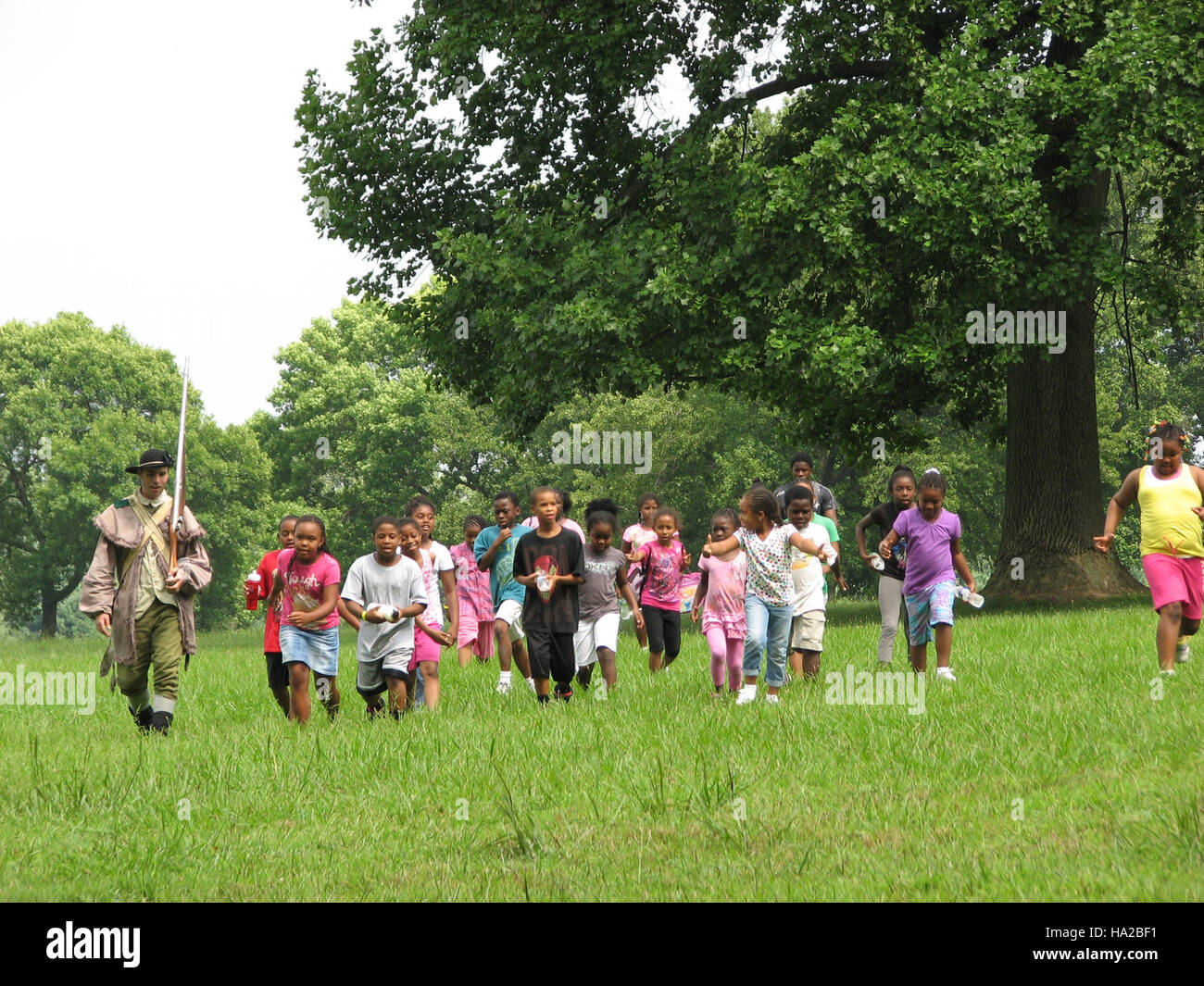Dieses Bild zeigt eine Gruppe von Besuchern, darunter Kinder, die an einer historischen Nachstellung oder einem marsch im Valley Forge National Park teilnehmen. Es beleuchtet die Bildungsprogramme des Parks, die Besuchern die Geschichte der amerikanischen Revolutionäre näher bringen sollen. Stockfoto