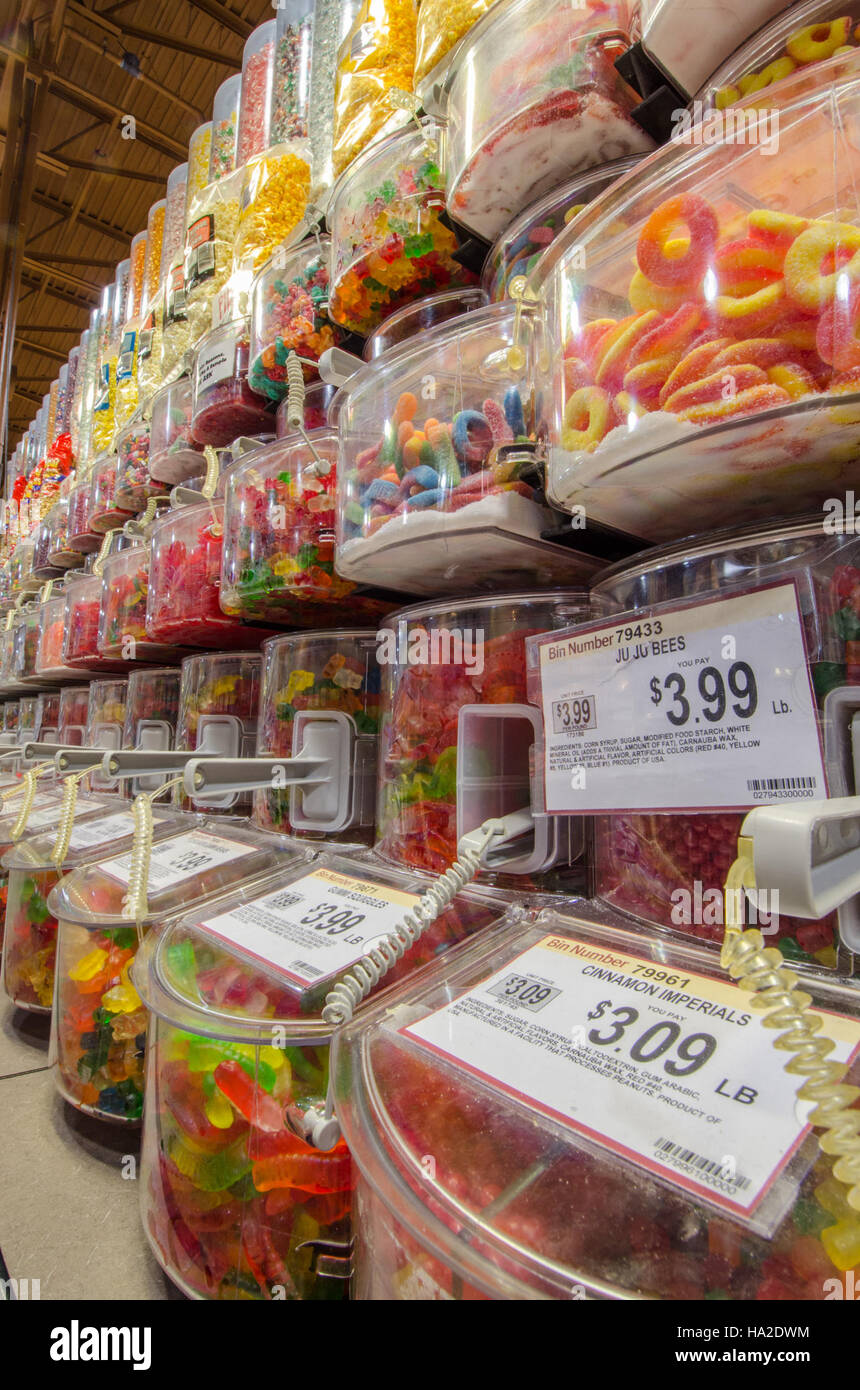 Dieses Bild zeigt die Vielfalt an Produkten, die in einem typischen Lebensmittelgeschäft erhältlich sind, darunter Süßigkeiten, Schokolade, Obst, Produkte, und Gemüse. Die Produkte sind Teil der umfassenderen Lebensmittelversorgungskette und des Verbrauchermarktes. Diese Geschäfte bieten eine Vielzahl von Angeboten für Käufer, die verschiedene Ernährungsgewohnheiten und Geschmäcker berücksichtigen, von Süßigkeiten bis hin zu frischen Produkten. Stockfoto