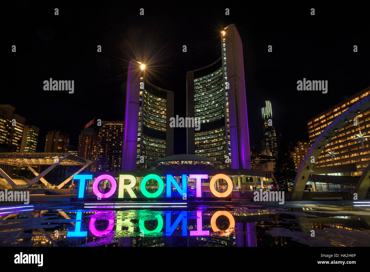 Toronto-Zeichen mit dem beleuchteten Rathaus in der Nacht, in Toronto, Kanada Stockfoto