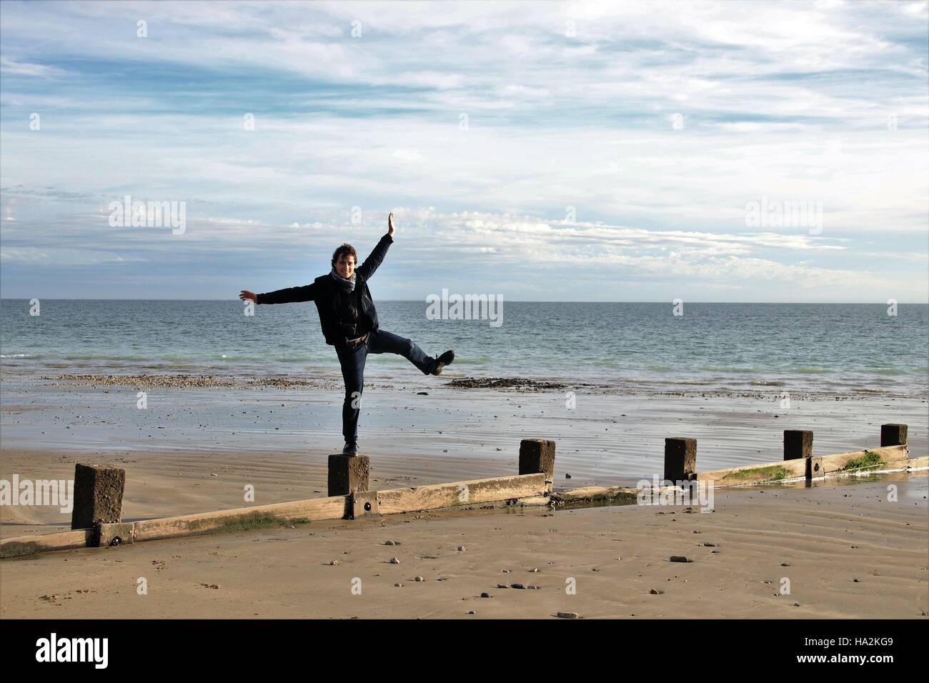 Mann auf hölzernen Pfosten am Strand, La Rochelle, Frankreich Stockfoto