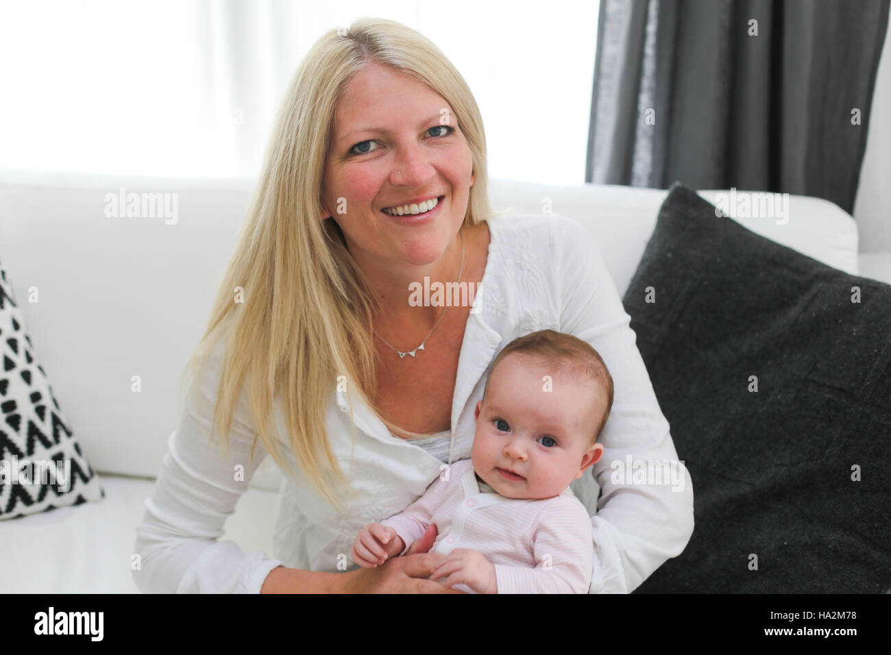 Porträt einer Smiling Mutter hält Babymädchen Stockfoto