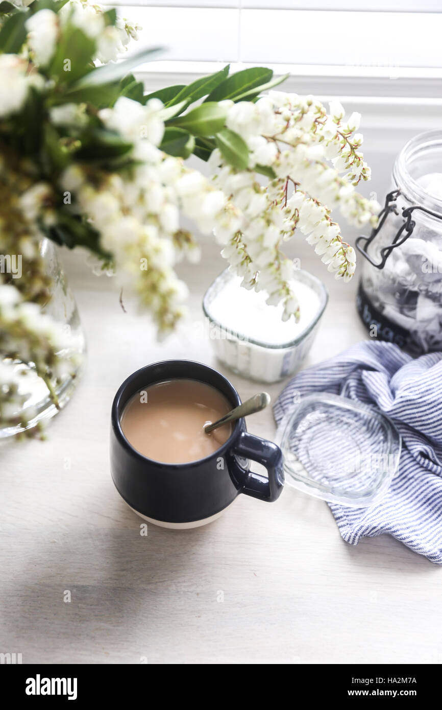 Tasse Tee und Vase mit Blumen Stockfoto