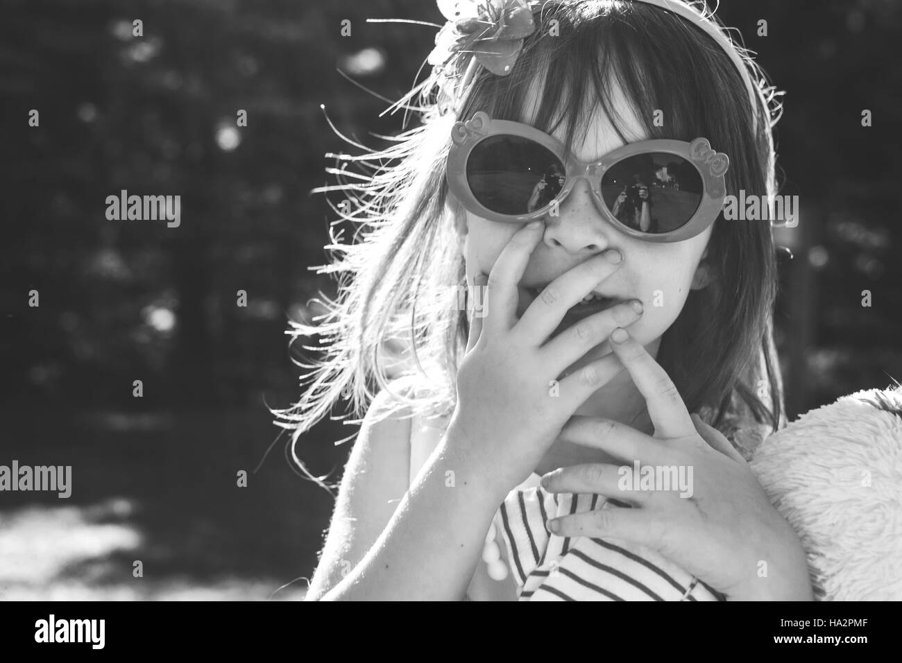 Porträt eines Mädchens in Sonnenbrille mit den Händen im Gesicht Stockfoto