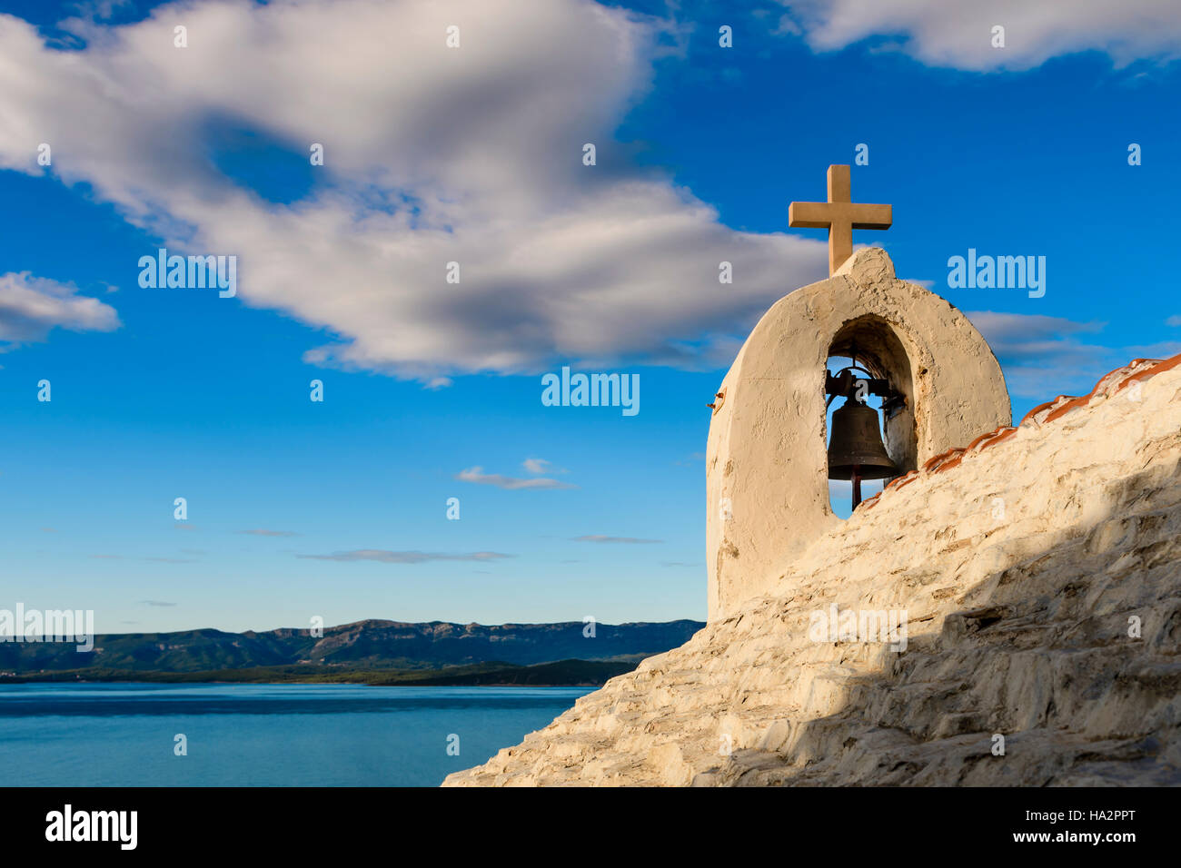 Kleine steinerne Kapelle im Mittelmeer, Insel Brac, Kroatien / morgen Tageslicht, Hvar im Hintergrund Stockfoto