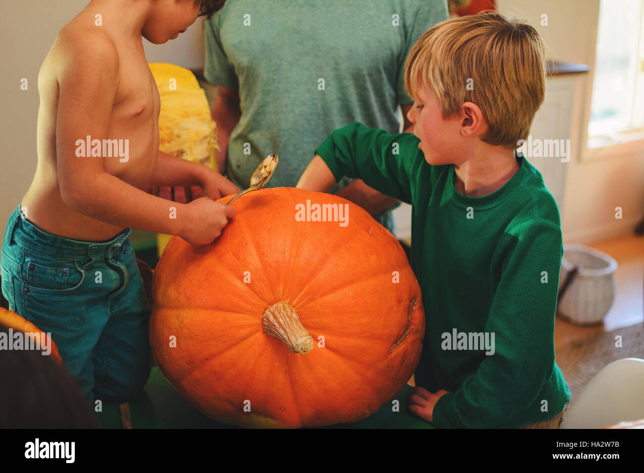 Vater und zwei Söhne schnitzen Kürbisse für Halloween Stockfoto