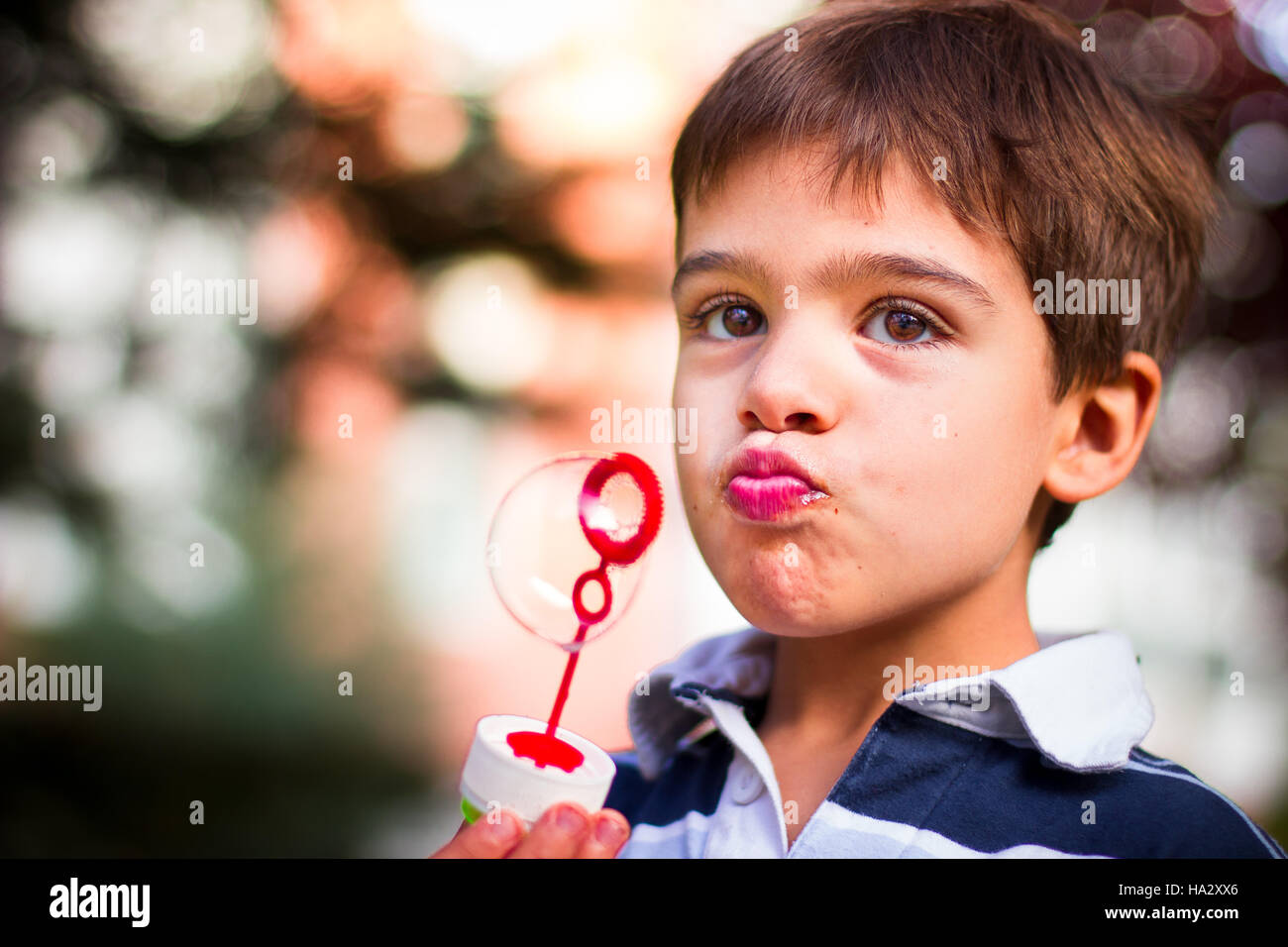 Junge hält Blase Wand bläst Seifenblasen Stockfoto