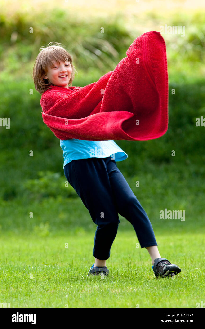 Junge rote Handtuch als Superhelden Mantel herumlaufen Stockfoto