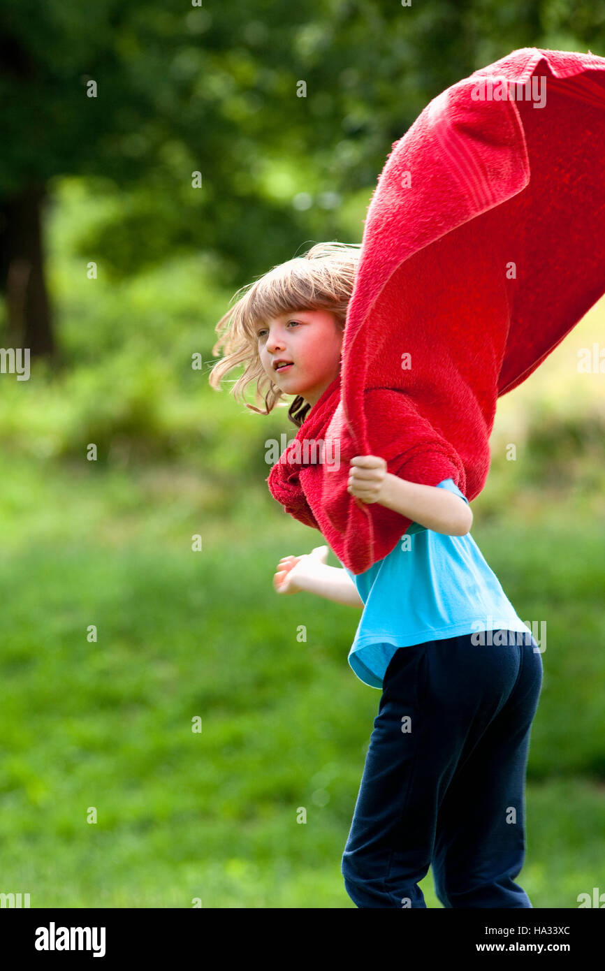 Junge rote Handtuch als Superhelden Mantel herumlaufen Stockfoto