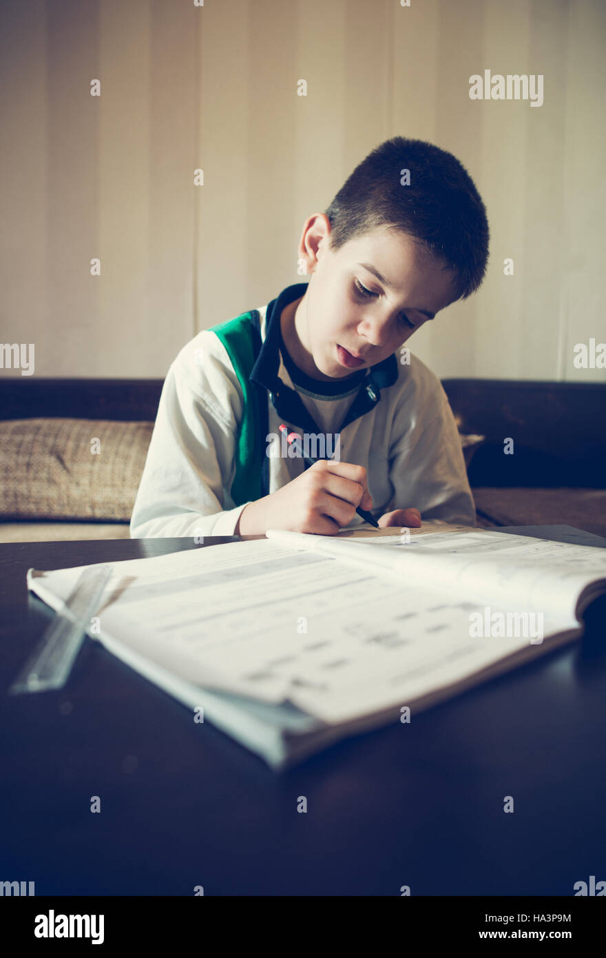 Kind seine Hausaufgaben machen. Notebook für Mathematik. Hand halten Stift. Jungen lernen Stockfoto