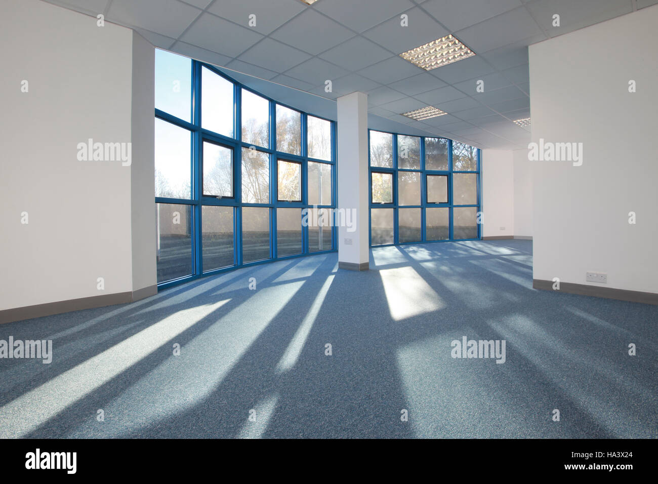 helle sonnendurchflutete leeren Büroraum mit Sonnenlicht durch Fenster Stockfoto