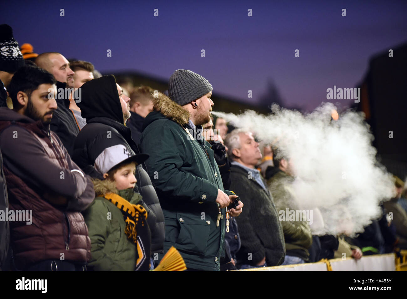 Mann, der beim Fußballspiel in der Menge dampft Großbritannien raucht Ausatmeende Vape Fans Fan Sportstadion Stockfoto