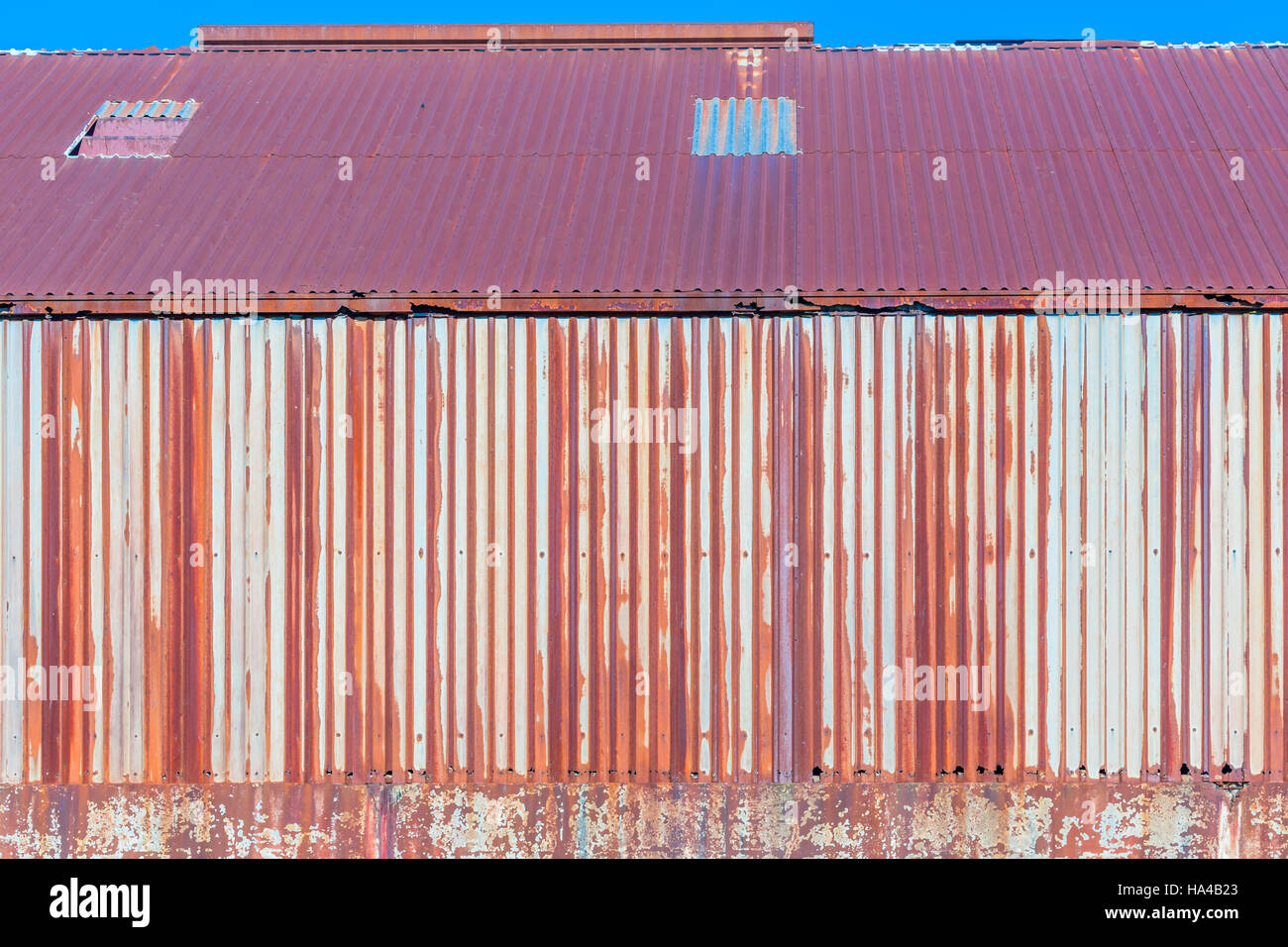 Detail eines Metalls Wellpappe Metall Gebäude komplett mit Rost und rote Farbe Stockfoto