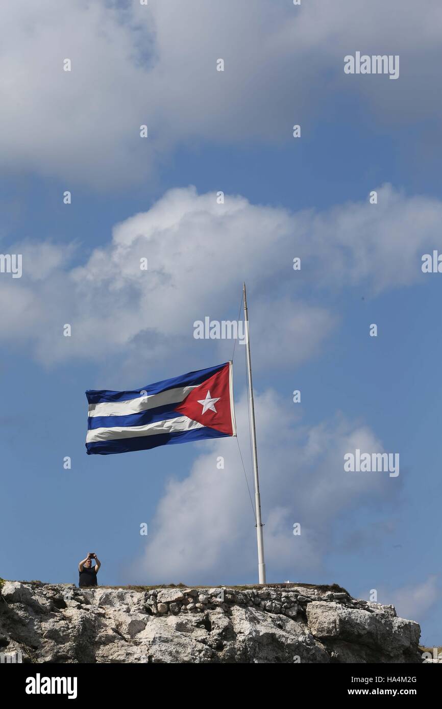 Havanna, Kuba. 27. November 2016. Ein Tourist fotografiert von einer kubanischen Nationalflagge auf Halbmast in Havanna, Kuba, am 27. November 2016. Kuba am Sonntag für eine nationale Hommage an Revolutionsführer Fidel Castro vorbereitet. © David De La Paz/Xinhua/Alamy Live News Stockfoto