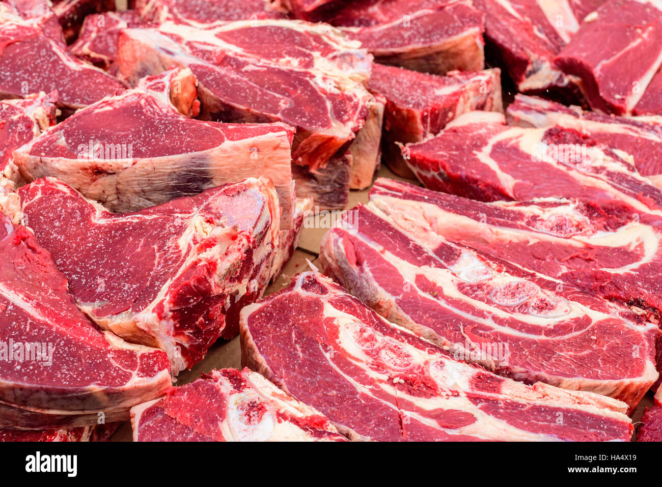 Haufen von frisch geschlachteten Rind stapeln sich auf einen Tisch für die Anzeige. Das Kuh-Fleisch ist eine lebendige rote Farbe. Stockfoto