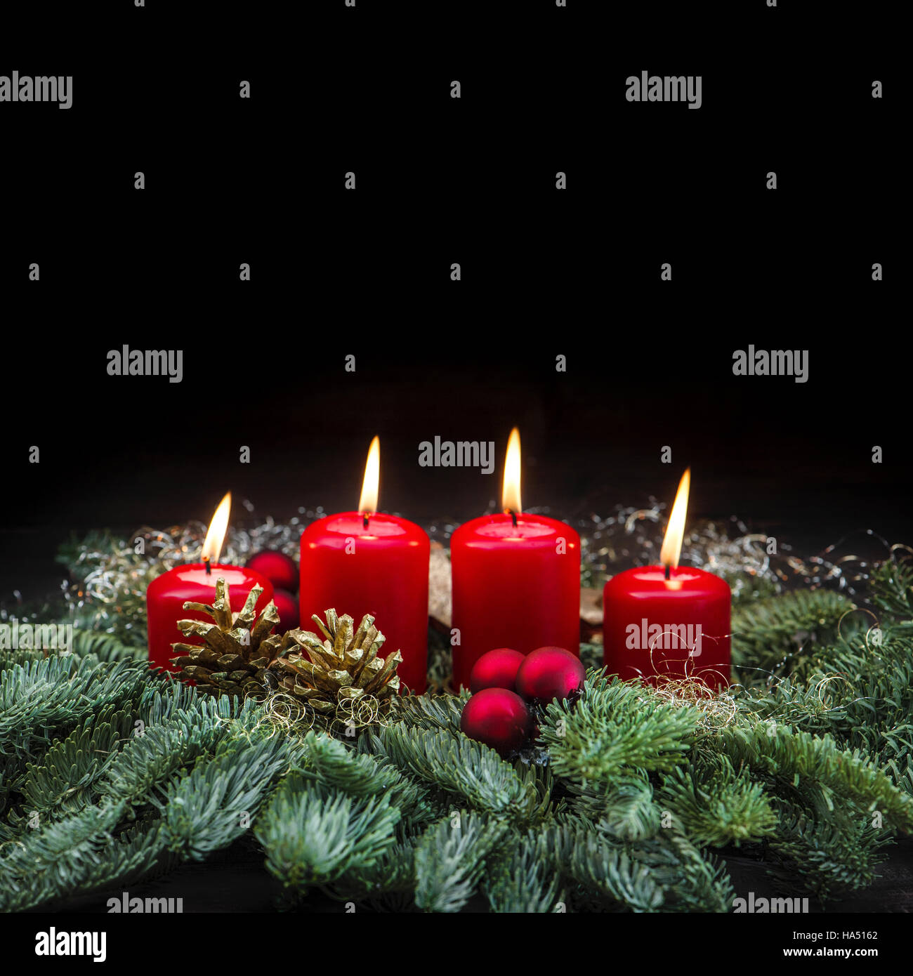 Advent Dekoration vier rote brennende Kerzen und Weihnachtsbaum Äste auf schwarzem Hintergrund Stockfoto
