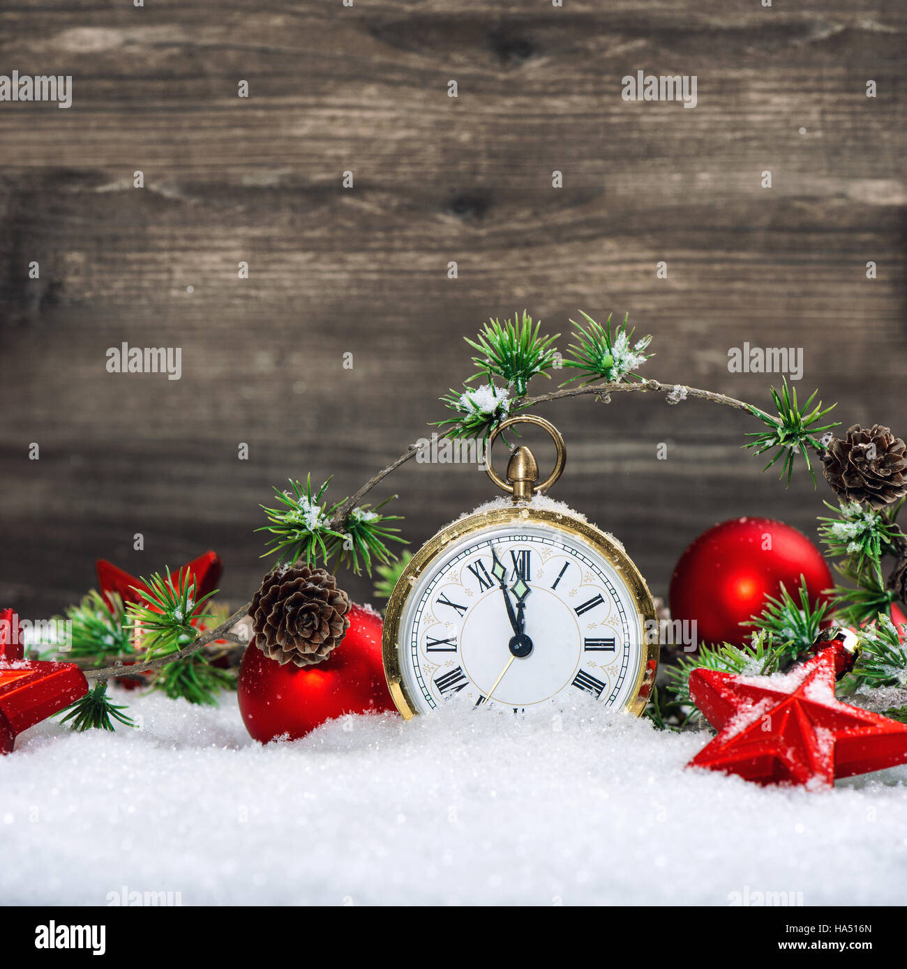 Weihnachten Dekoration antike goldene Uhr und roten Ornamenten im Schnee Stockfoto