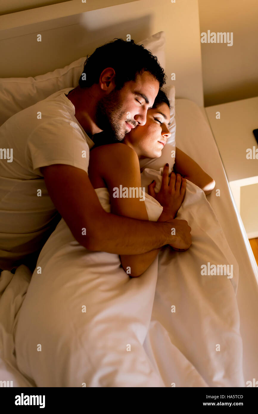 Junges Paar im Bett umarmt Stockfoto