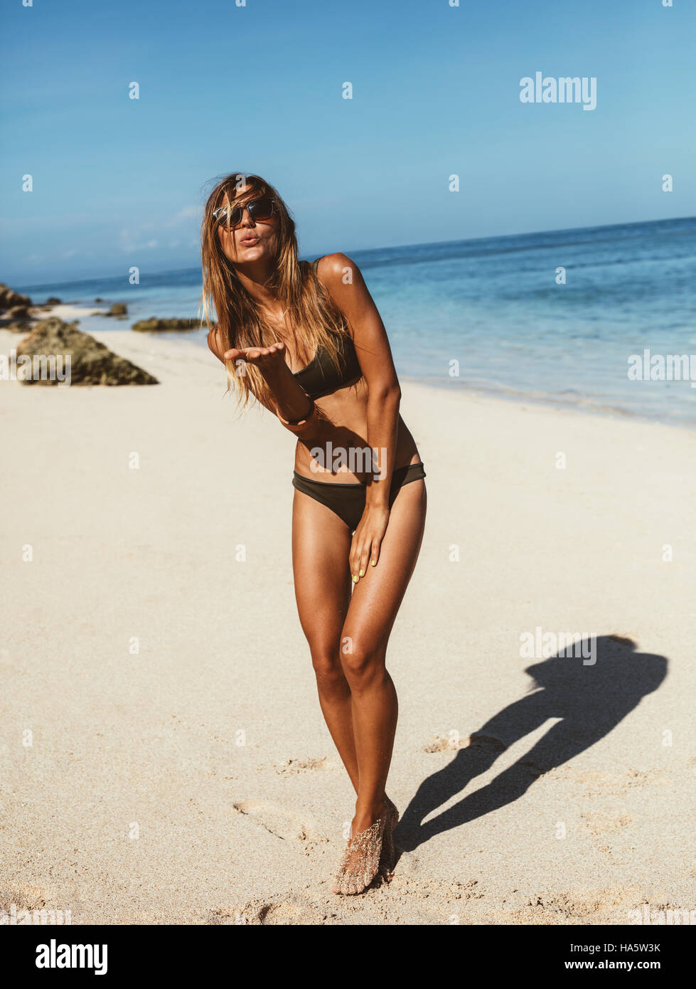 In voller Länge Portrait schöne junge Frau am Strandurlaub Spaß. Weibliches Model tragen Bikini stehen am Ufer Meeres. Stockfoto